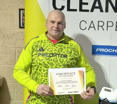 Mark holding his carpet cleaning certificate of attendance.